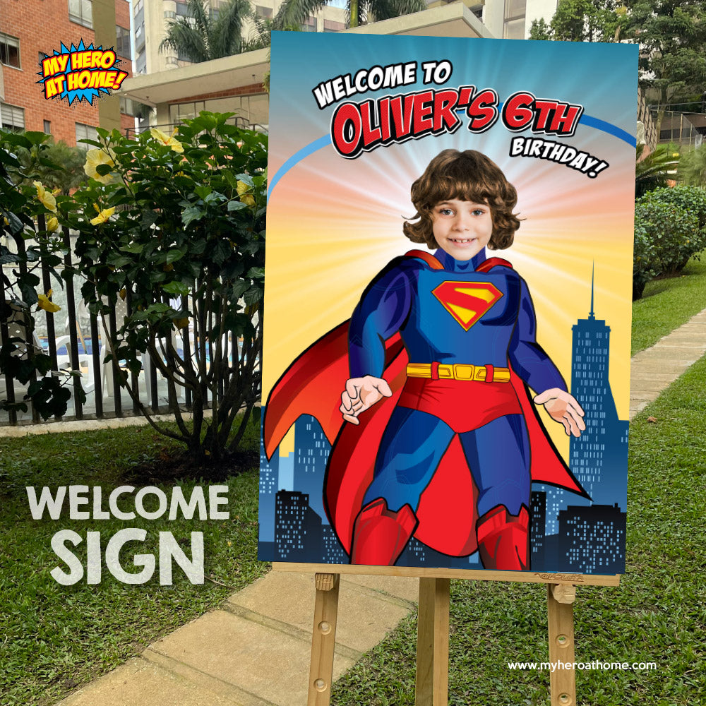 Birthday welcome sign with a child in a Superman costume against a cityscape background.